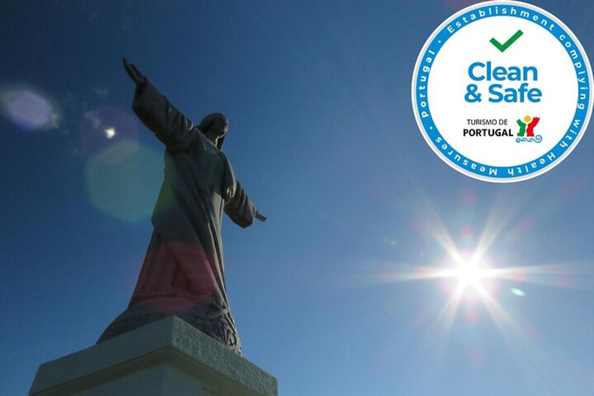 a statue of a redeemer with the sun in the sky