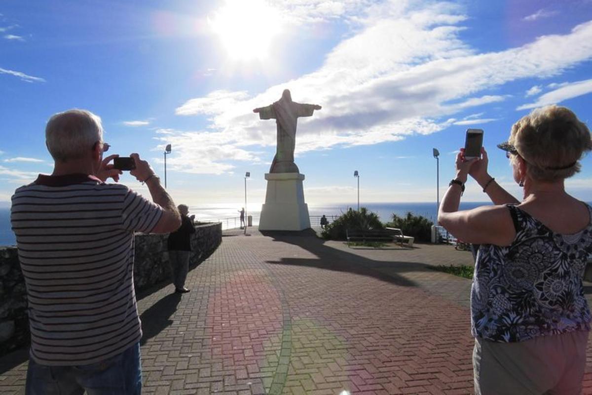 a man and woman taking pictures of a statue