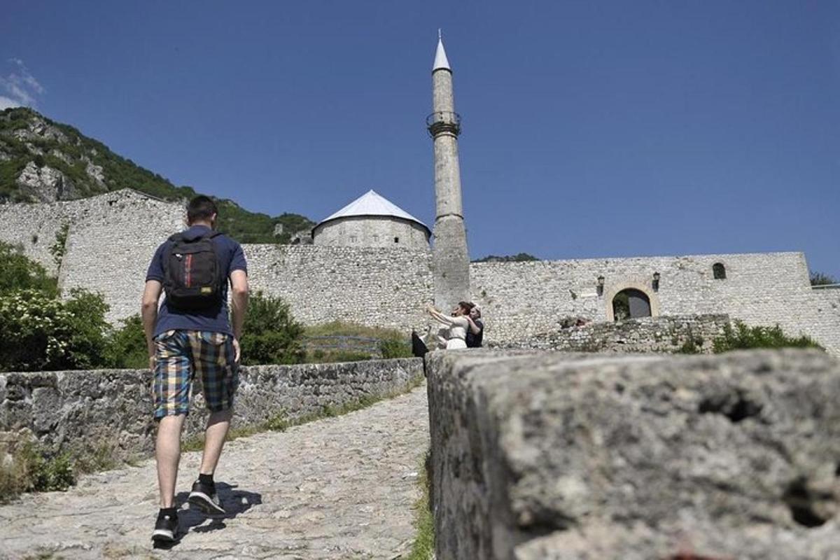 a man with a backpack walking towards a castle
