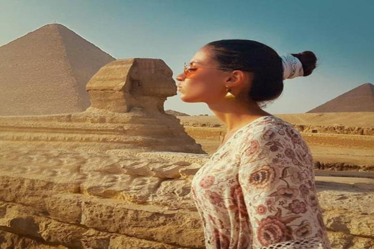 žena stojaca pred pyramídami