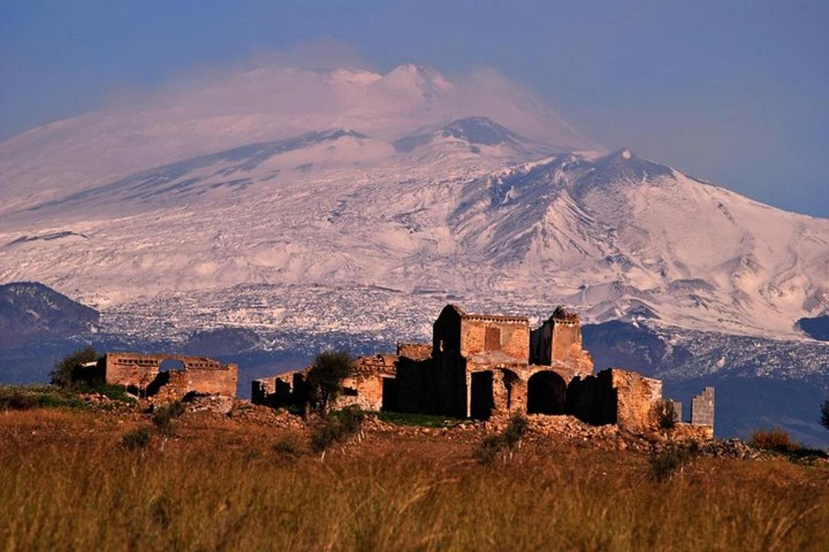 un vecchio edificio su una collina di fronte a una montagna