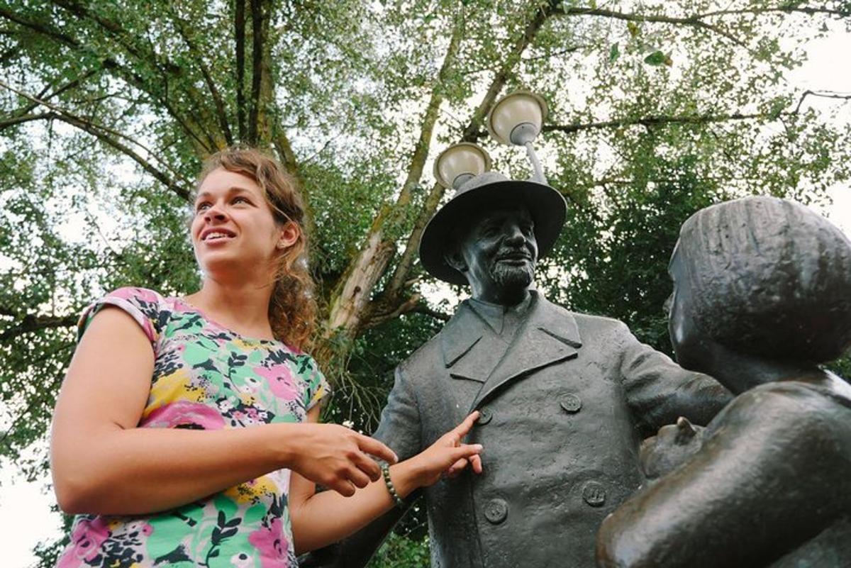 a woman standing next to a statue of a man