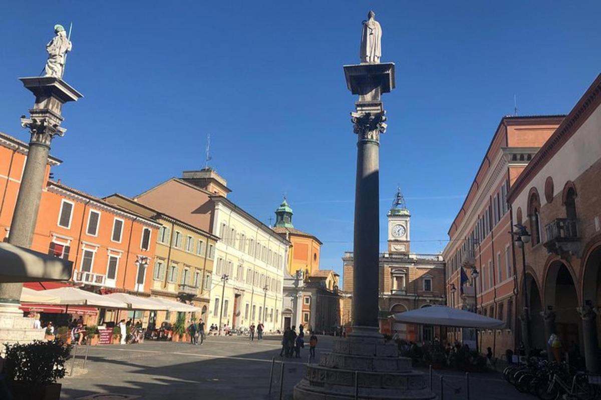 una strada cittadina con un grande palo con una torre dell'orologio