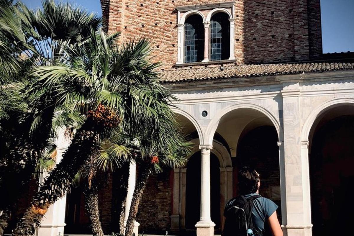 un uomo che cammina davanti a un edificio con palme