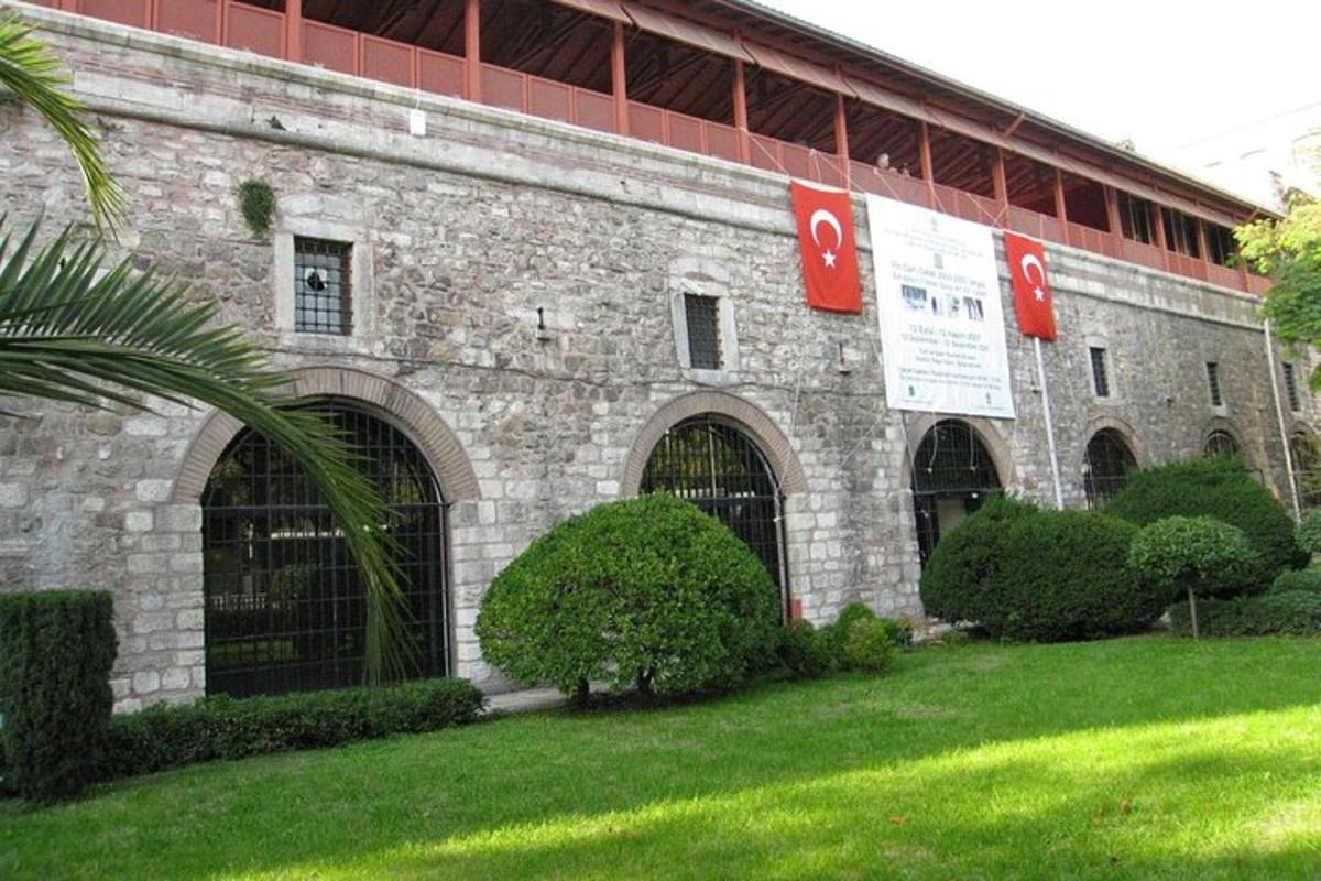 a large brick building with gates and bushes in a yard