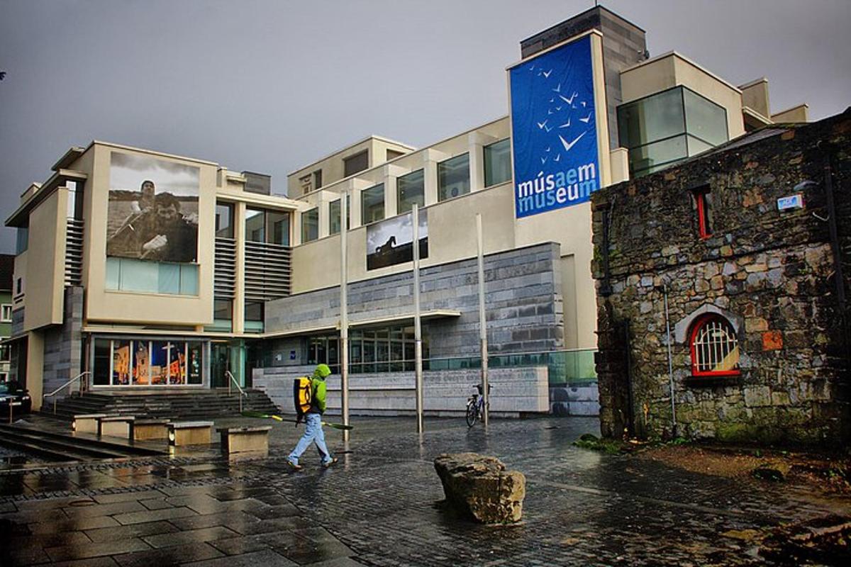 Un hombre caminando frente a un edificio bajo la lluvia.