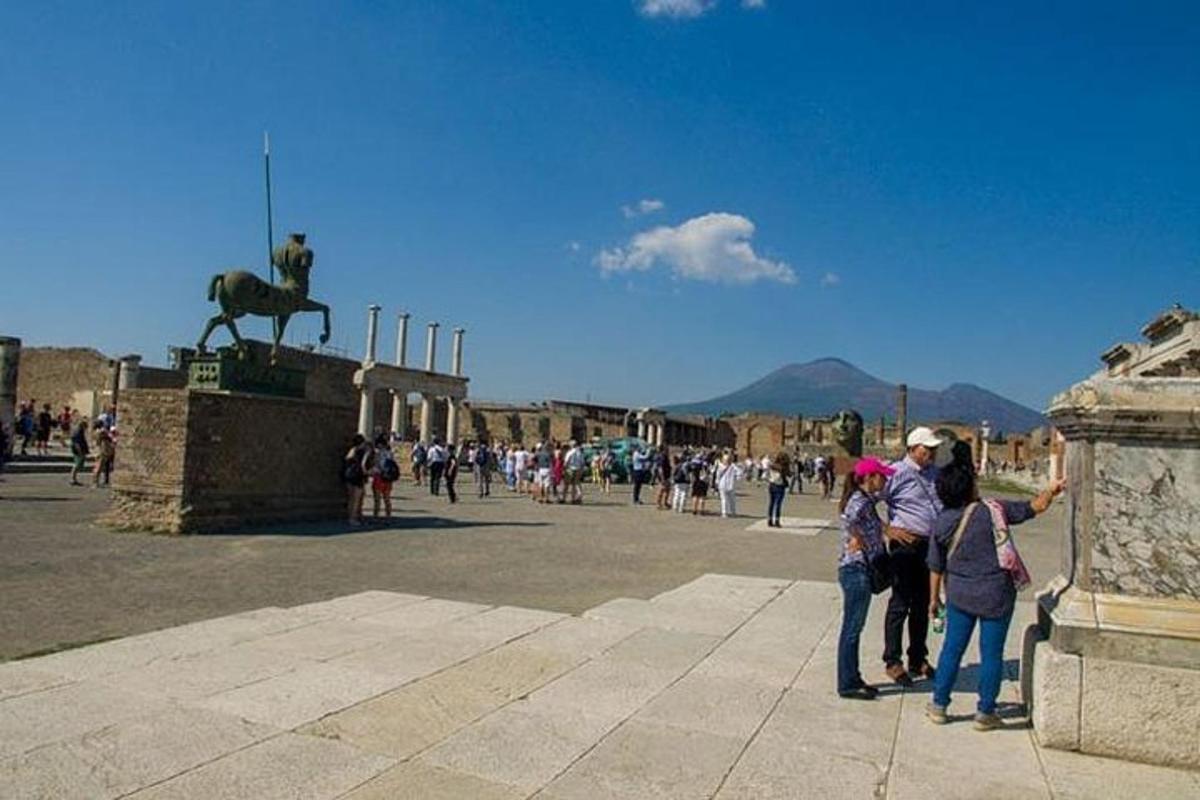 um grupo de pessoas em pé ao lado de uma estátua