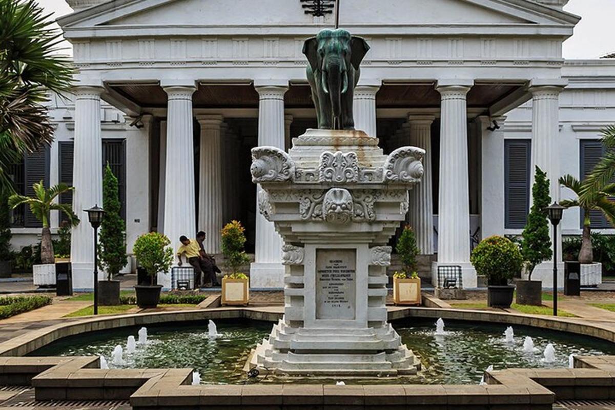 a statue in front of a building with a fountain