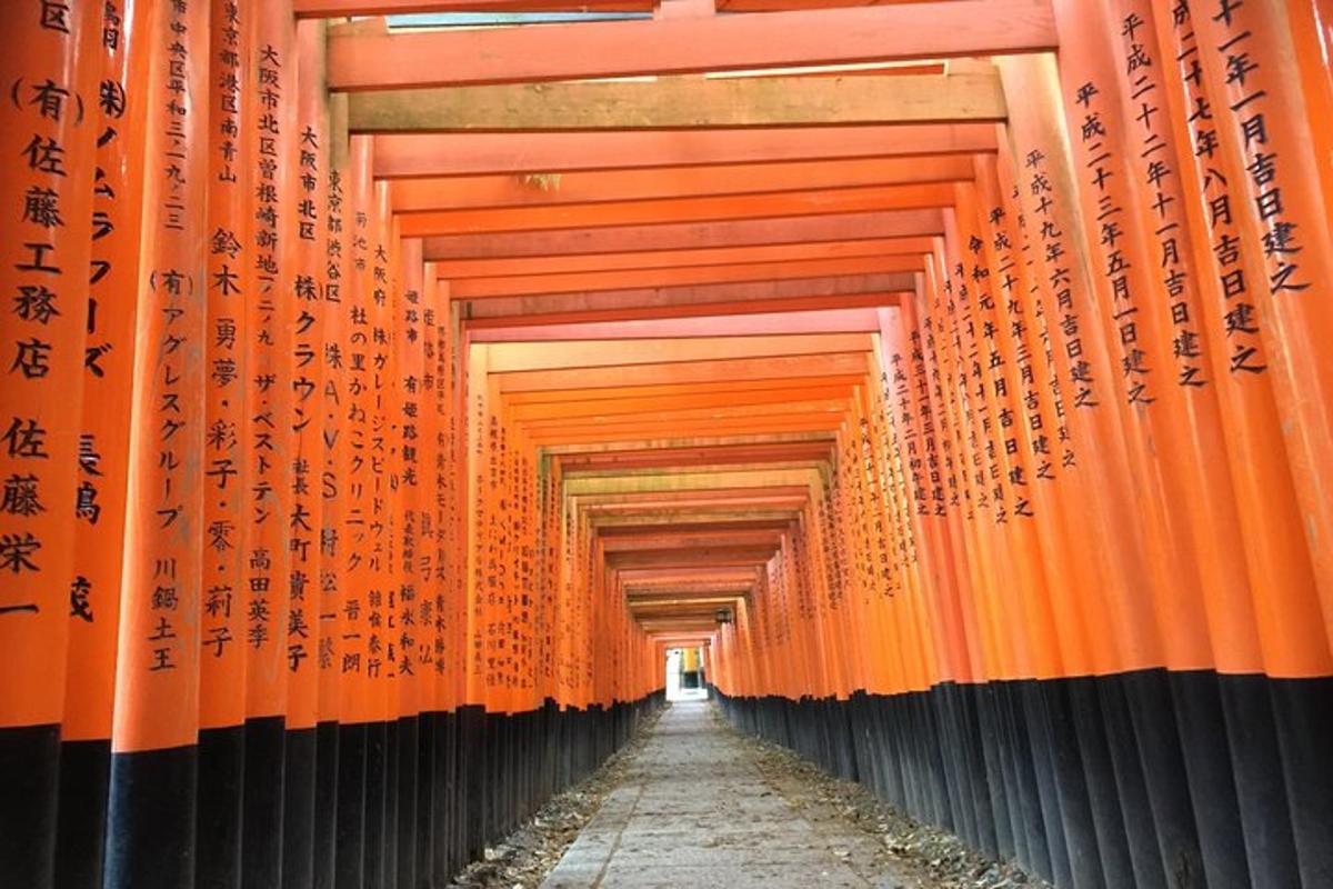 egy sor narancssárga torii kapu, rajtuk felirattal