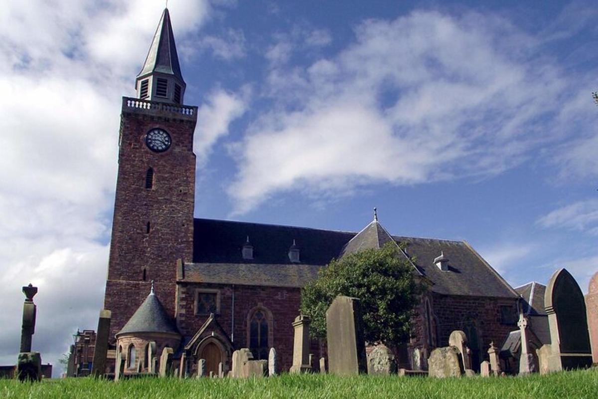 kirkja með klukkuturni í kirkjugarði