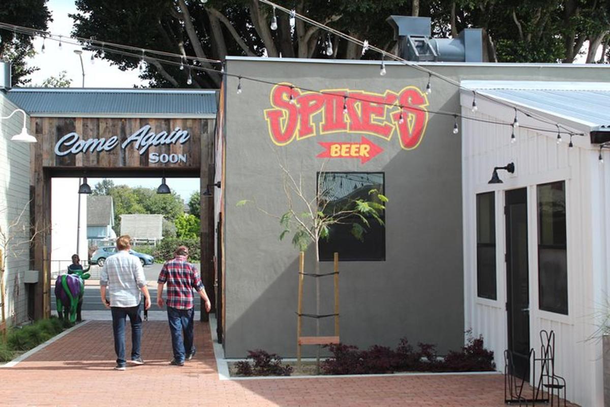 two men walking down a sidewalk outside of a restaurant