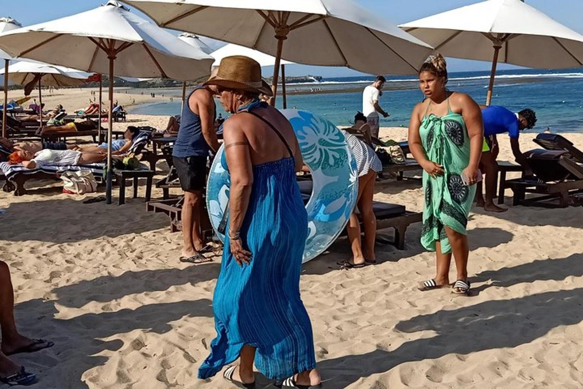 en kvinne i en blå kjole på en strand
