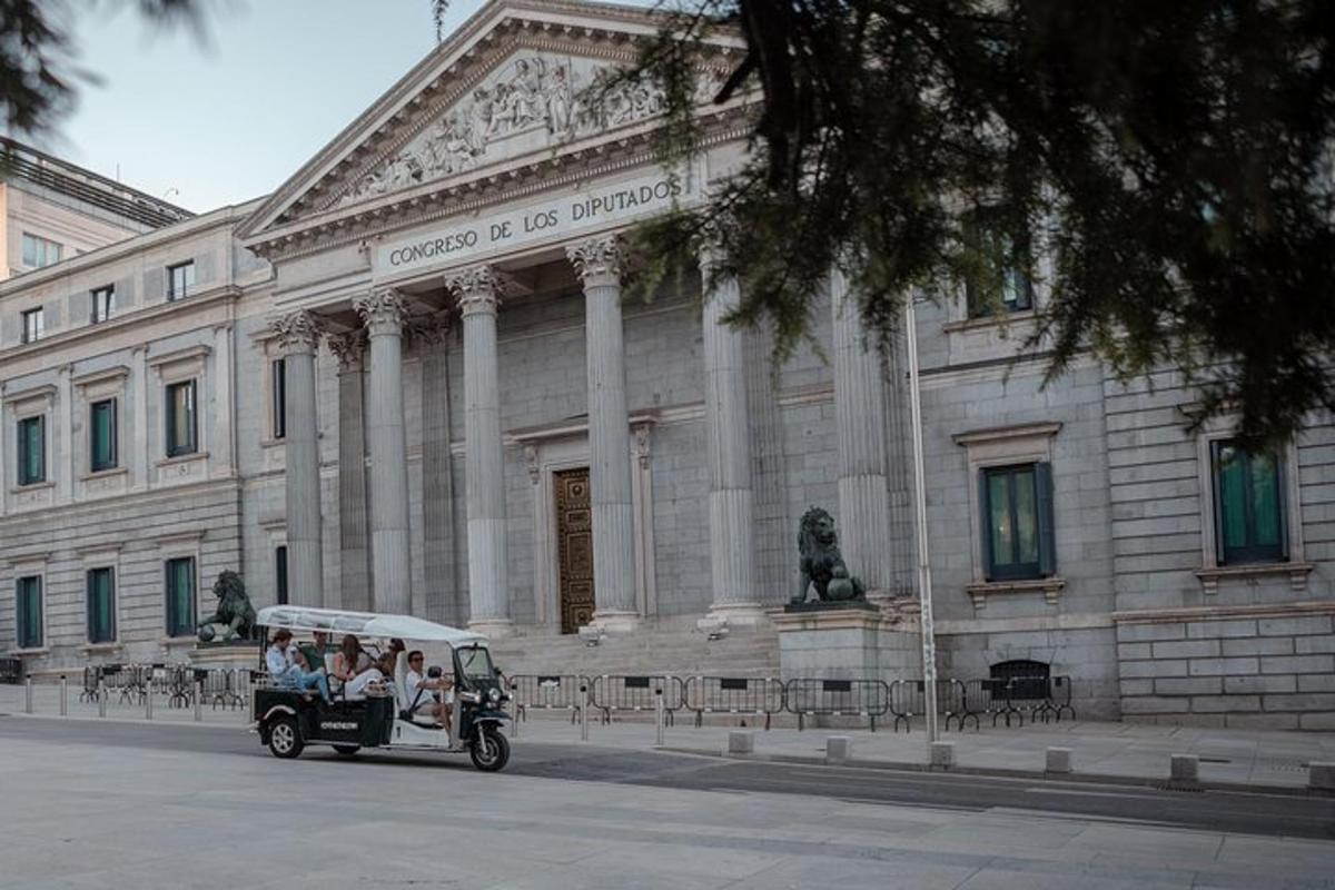 μια ομάδα ανθρώπων που επιβαίνουν σε ένα αυτοκίνητο μπροστά από ένα κτίριο