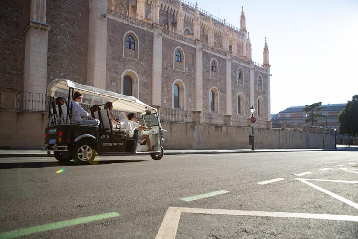 un cotxe vell circulant per un carrer davant d'un edifici