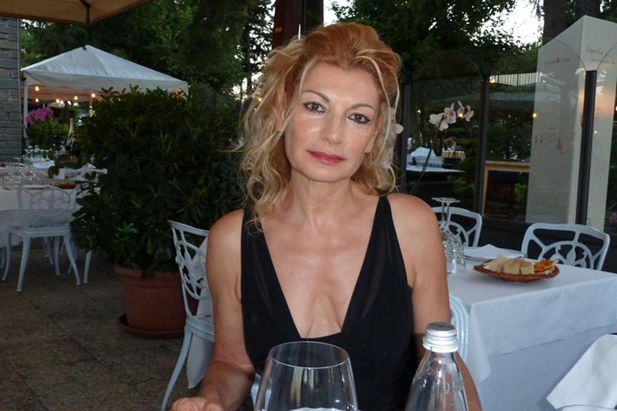 a woman sitting at a table with a glass of wine