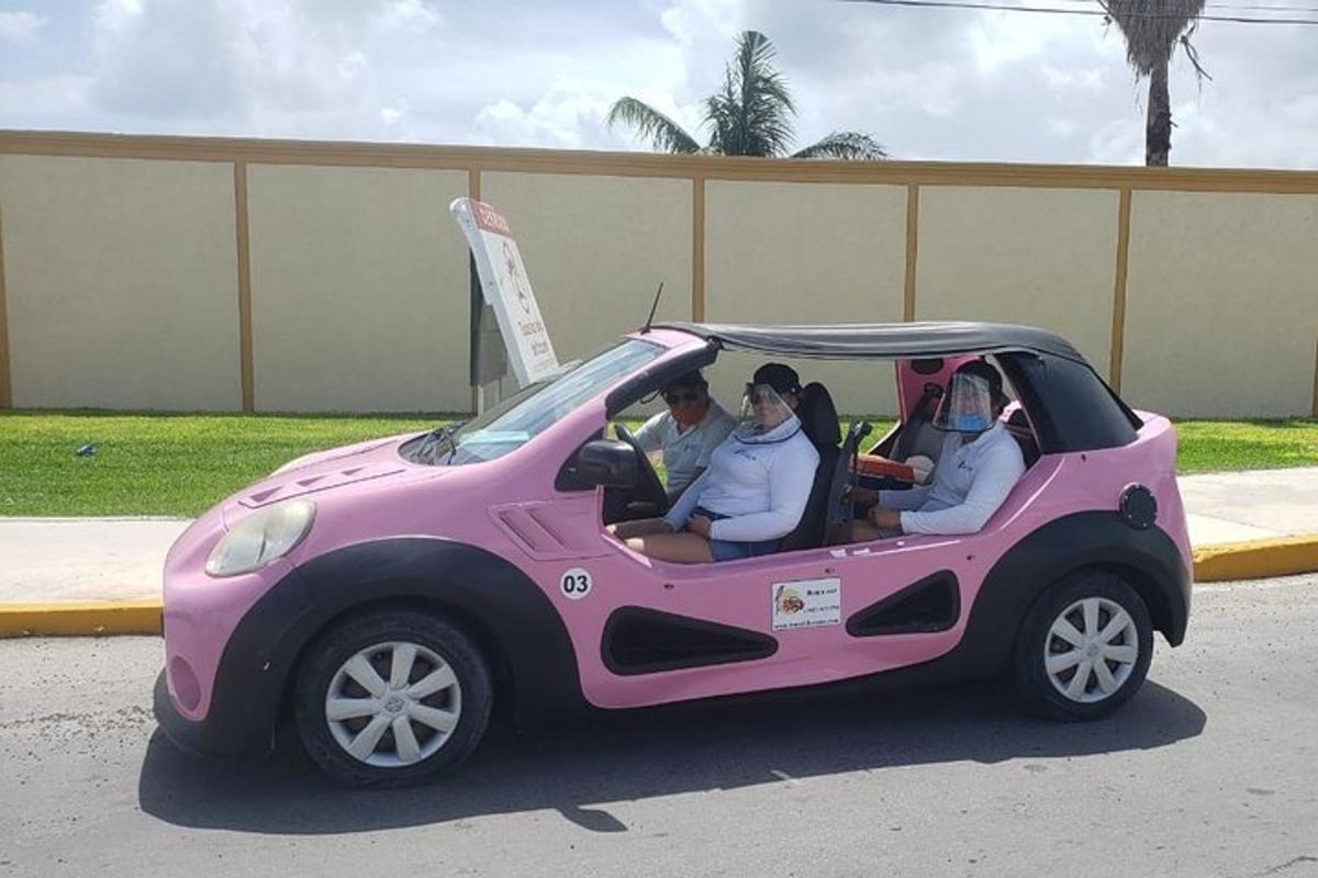 um grupo de pessoas sentadas em um carro rosa