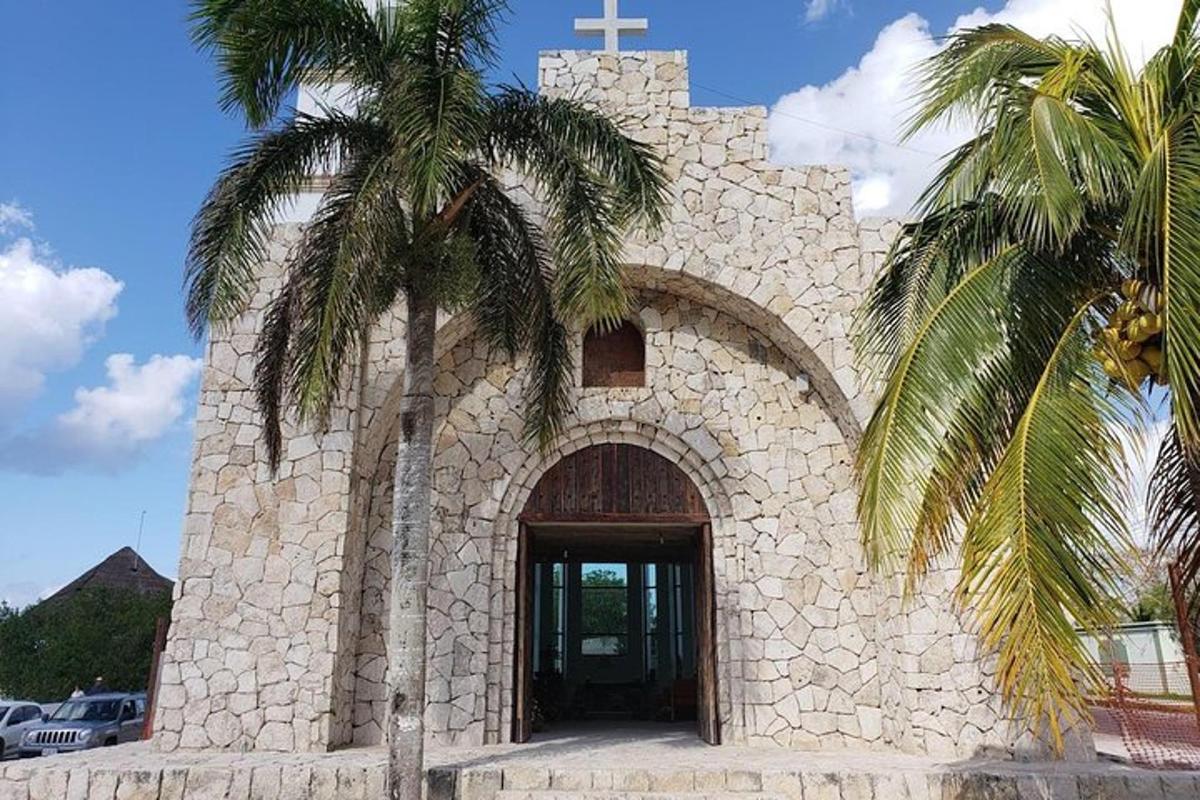 una iglesia con una cruz y una palmera