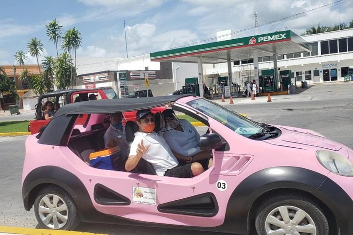 duas pessoas estão sentadas em um carro rosa