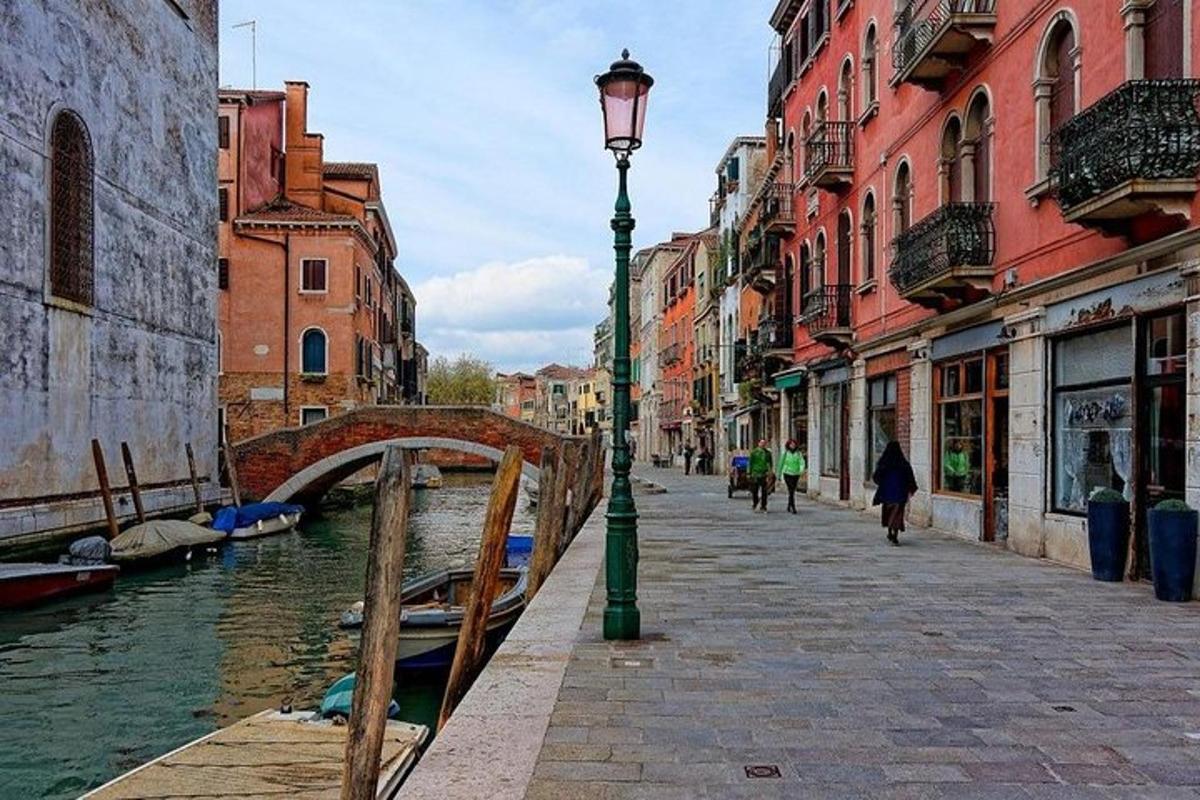 Una farola junto a un canal con un puente