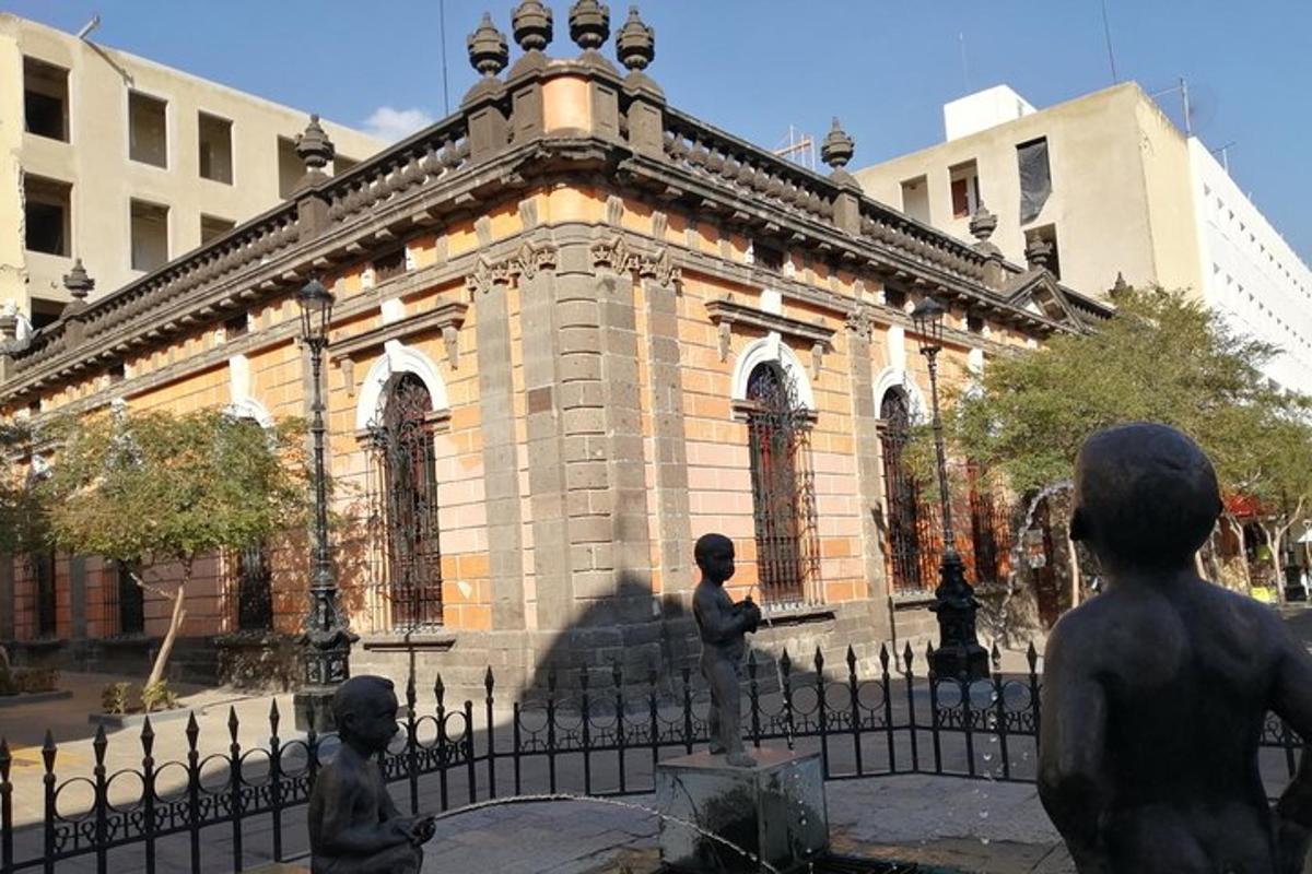 a building with statues in front of a fence