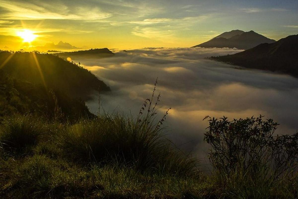 một quang cảnh của một thung lũng sương mù với mặt trời mọc trên những đám mây
