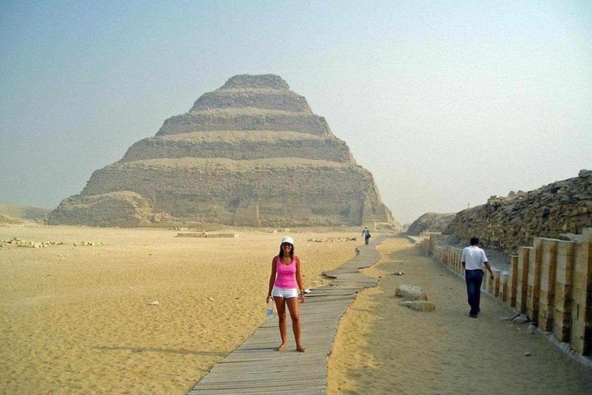 een vrouw die over een promenade voor de piramide loopt