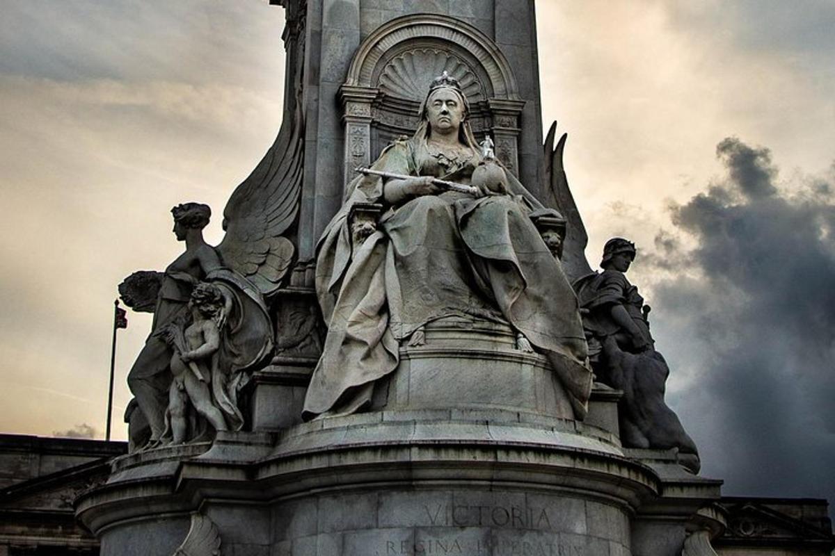 uma estátua de uma mulher sentada no topo de um prédio