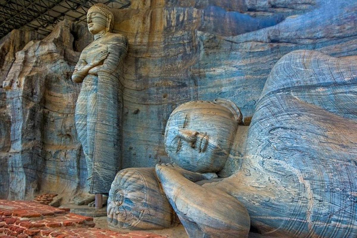 una statua di un uomo seduto su una parete rocciosa