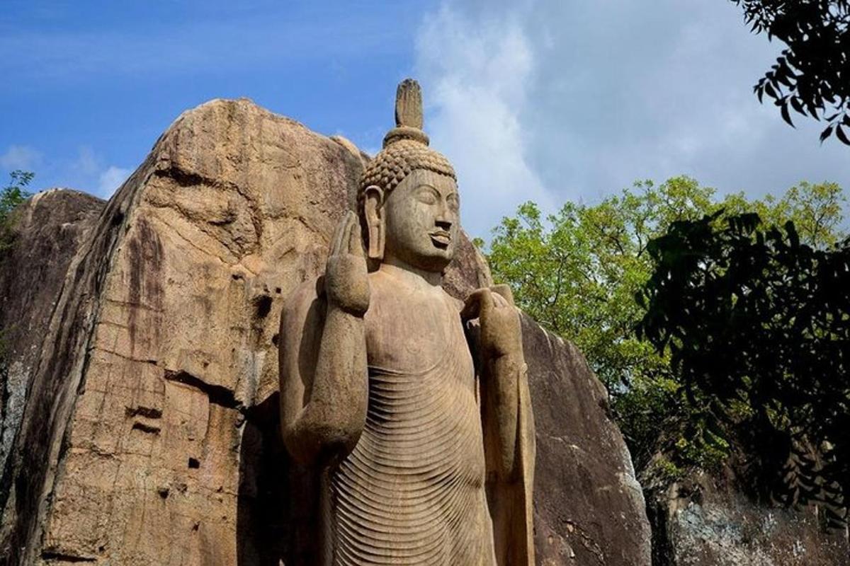una estatua parada frente a una gran roca