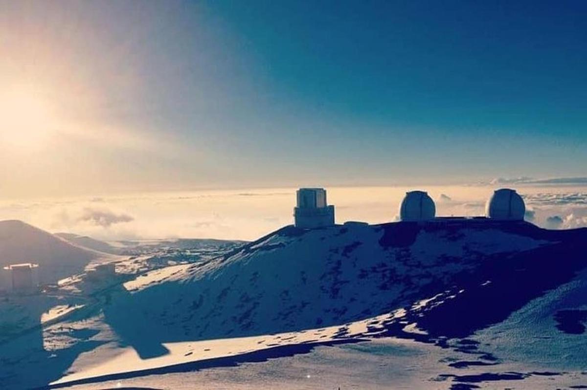 a snow covered mountain with buildings on top of it