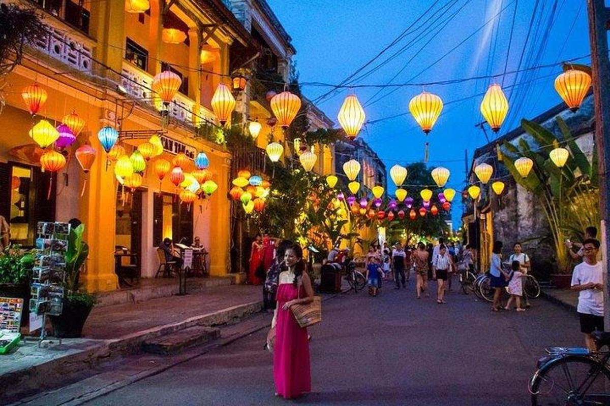 a woman is walking down a street with lanterns