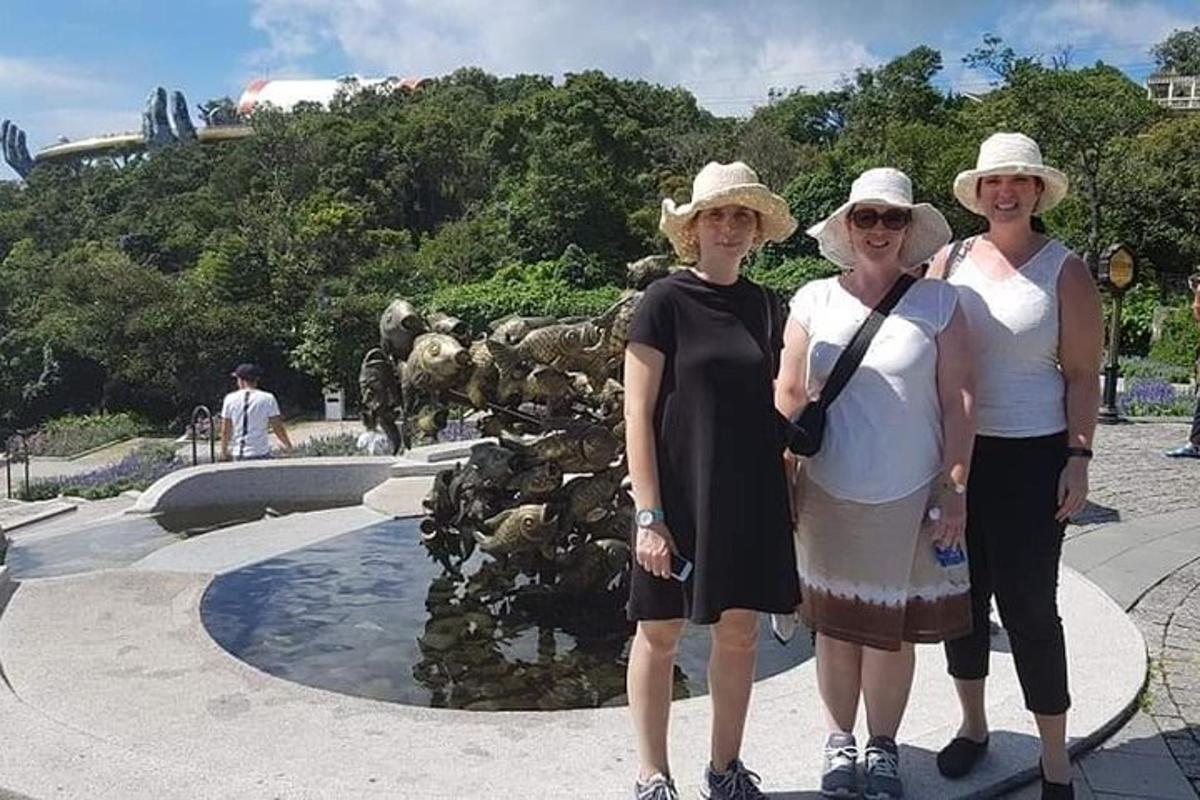 Un grupo de tres mujeres de pie frente a una fuente.