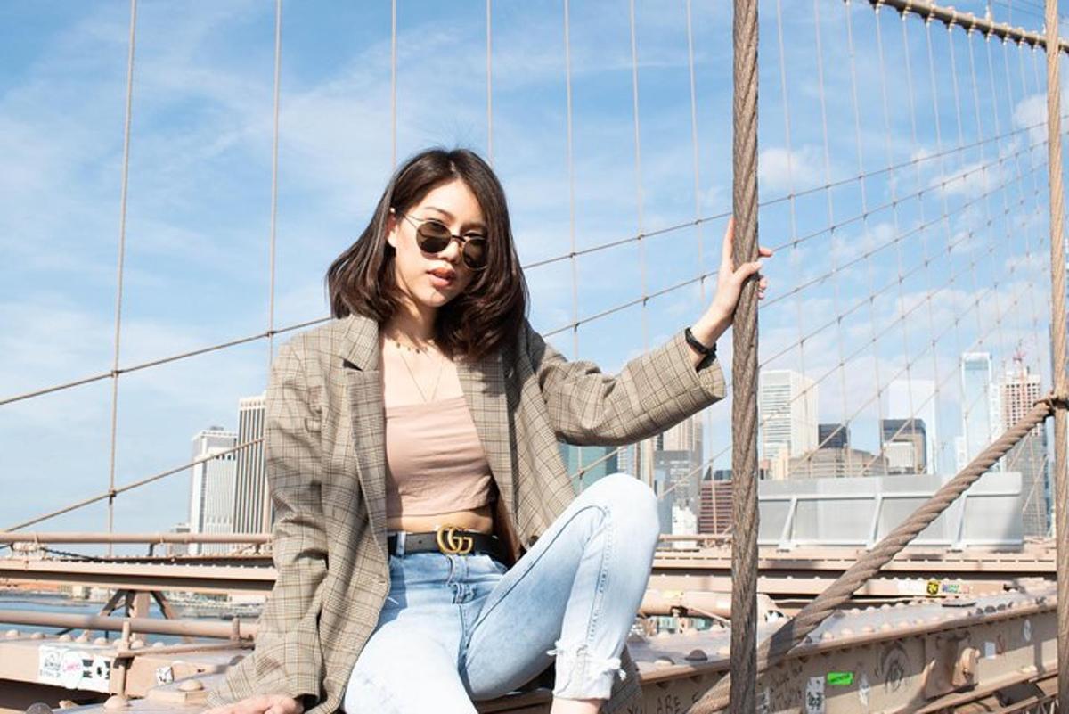 一位女士坐在城市前的一座桥上