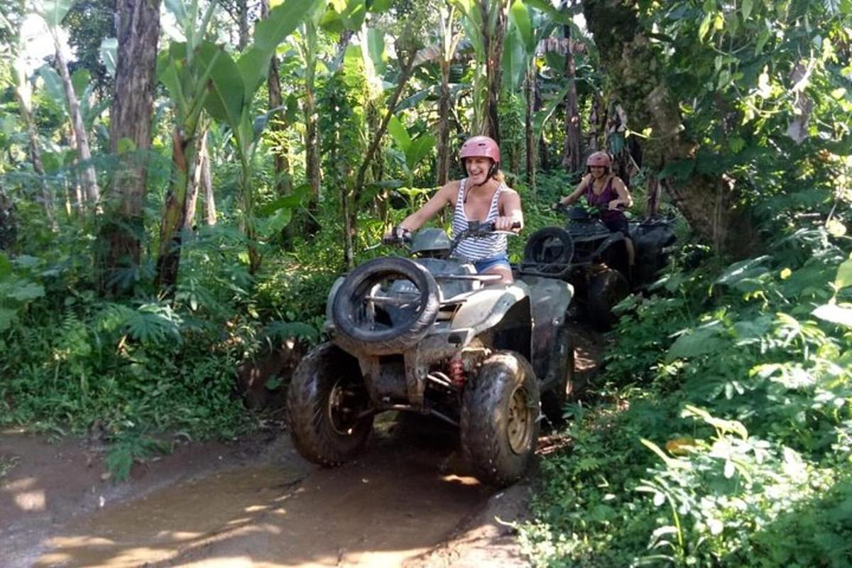 two people riding on atvs in the forest