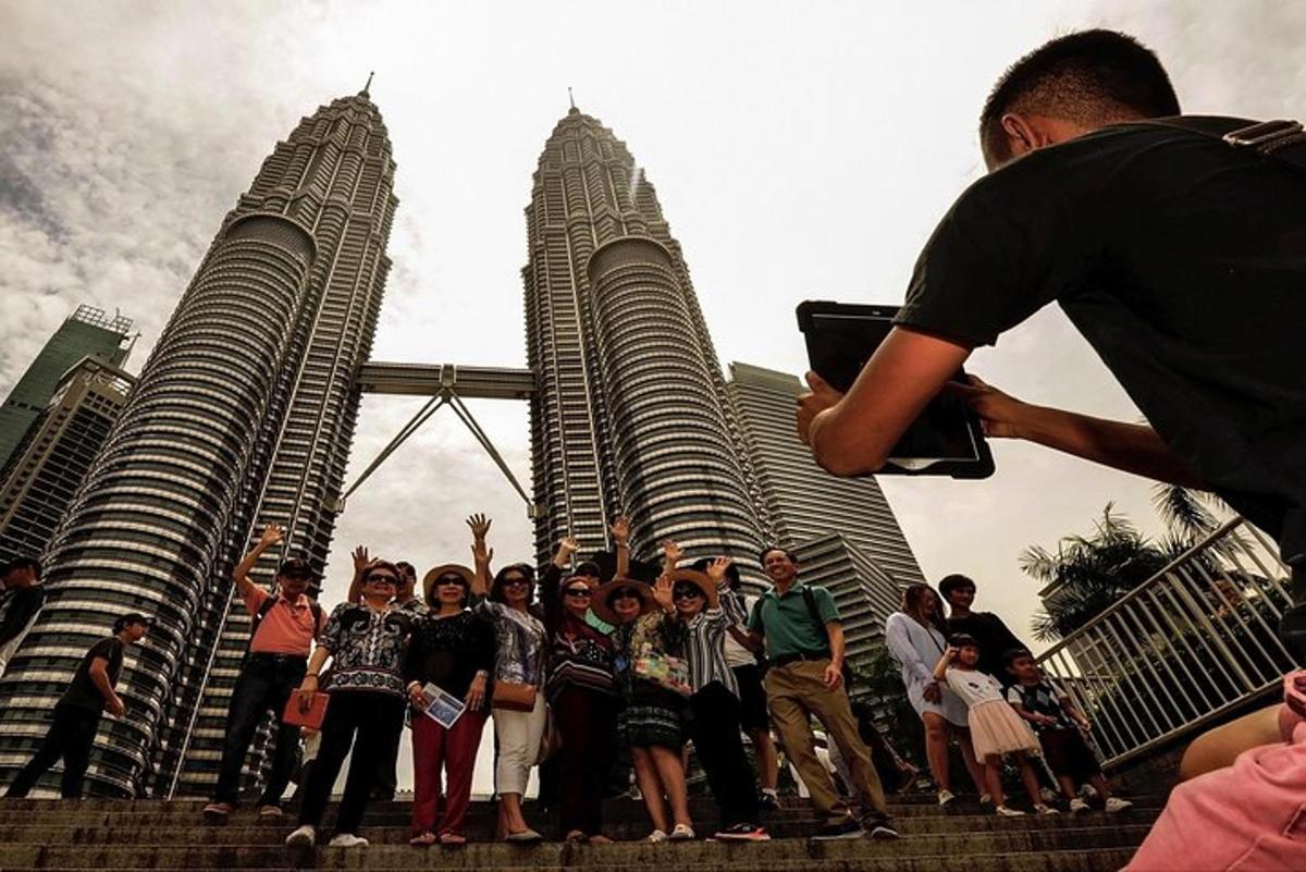 un grup de oameni care stăteau în fața turnurilor Petronas