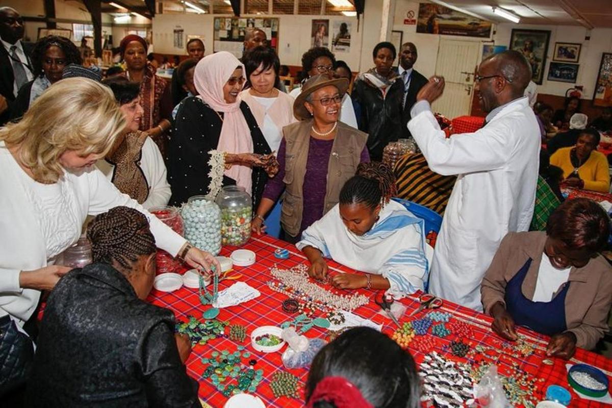 a group of people standing around a table with beads