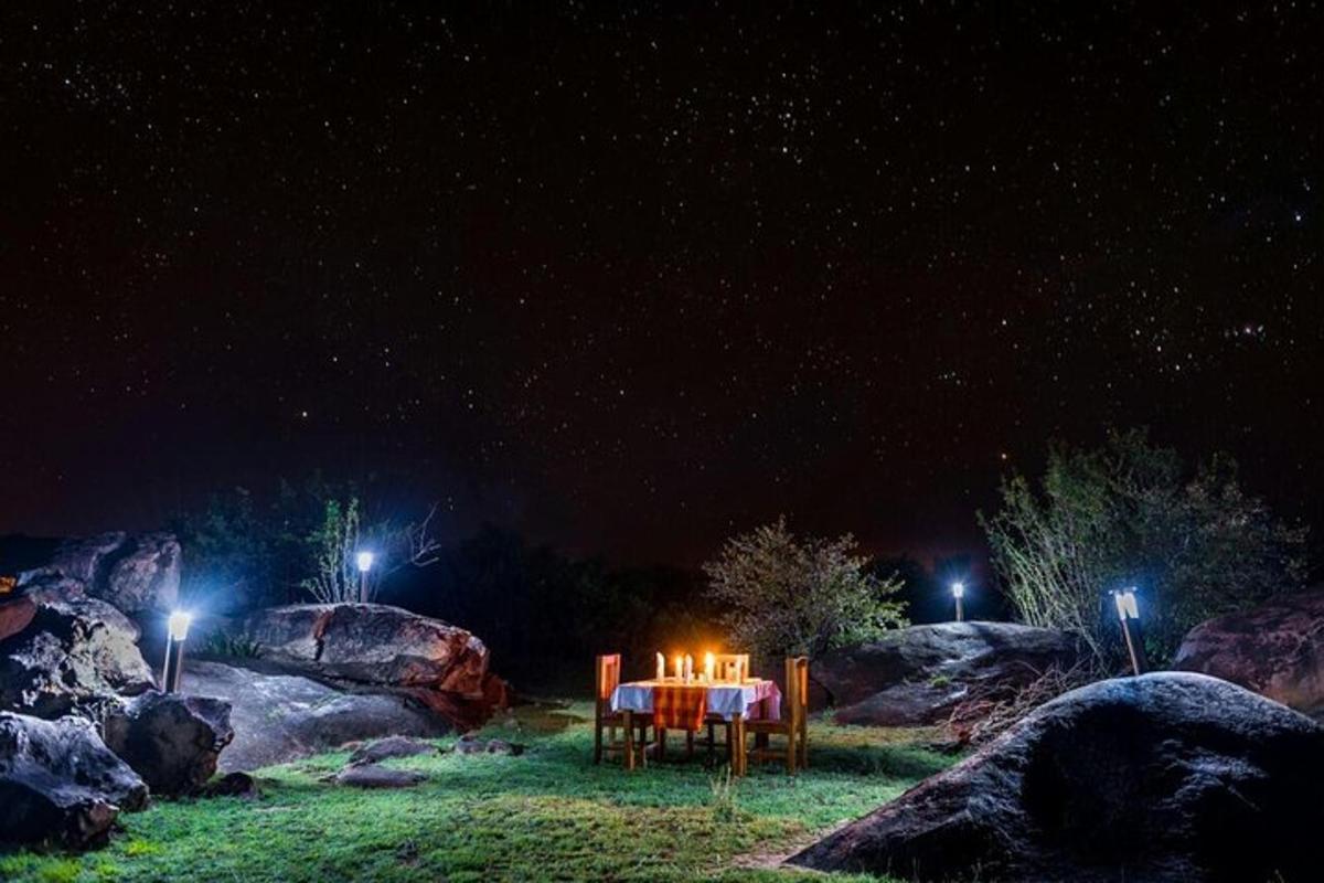 una taula amb espelmes en un camp a la nit