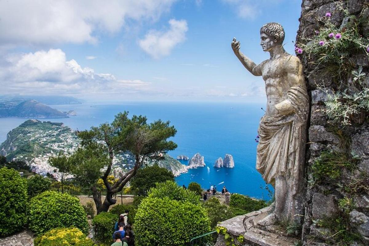 uma estátua de uma mulher em pé em um penhasco com vista para o oceano