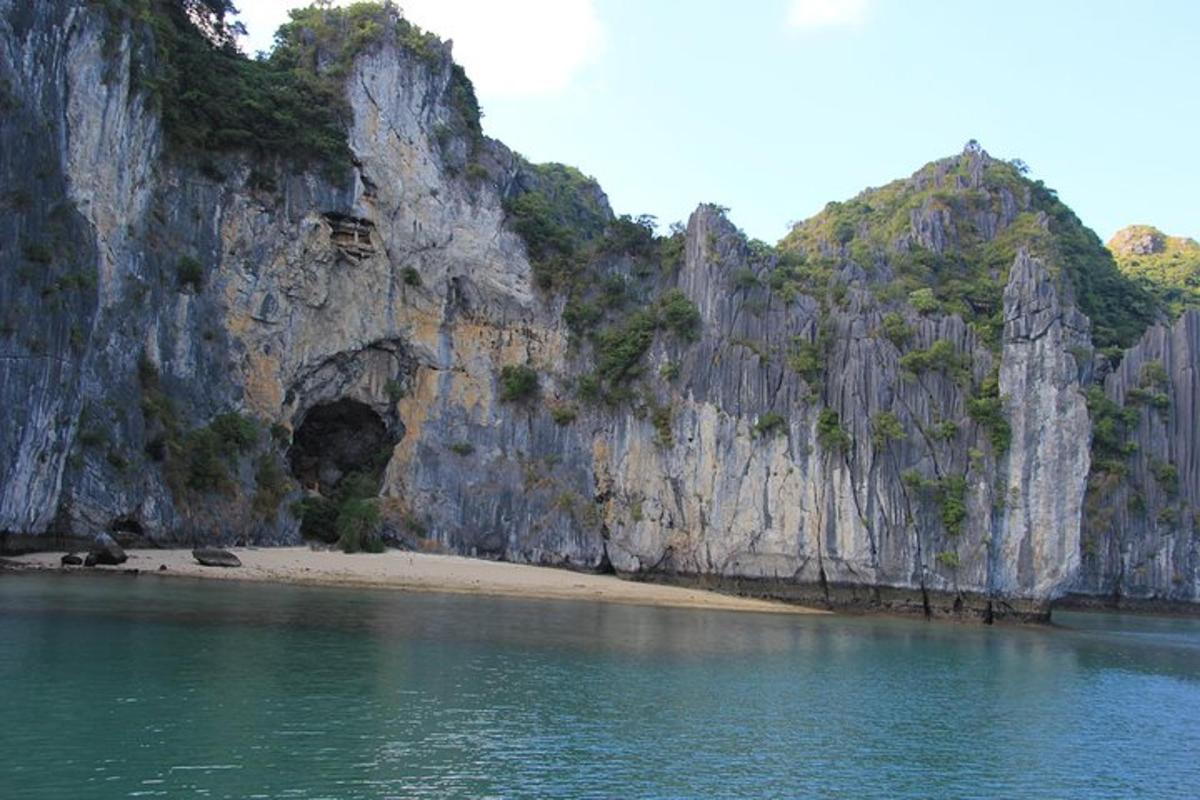 a beach with a rock wall next to the water