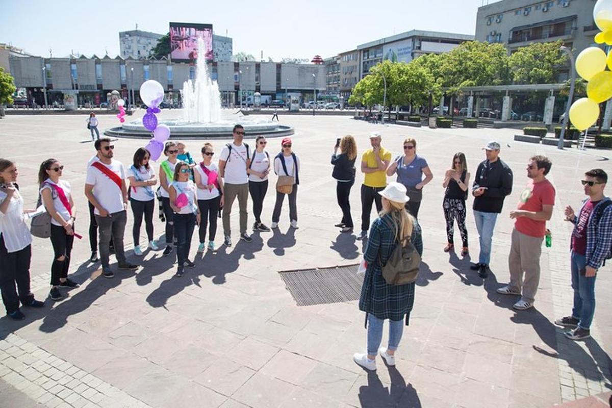 a group of people standing in front of a fountain