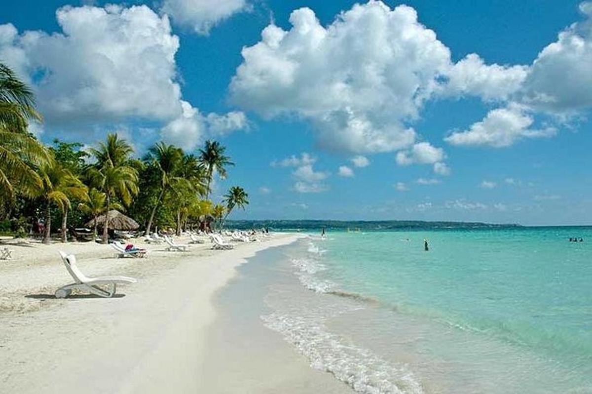 een strand met een stel stoelen en de oceaan