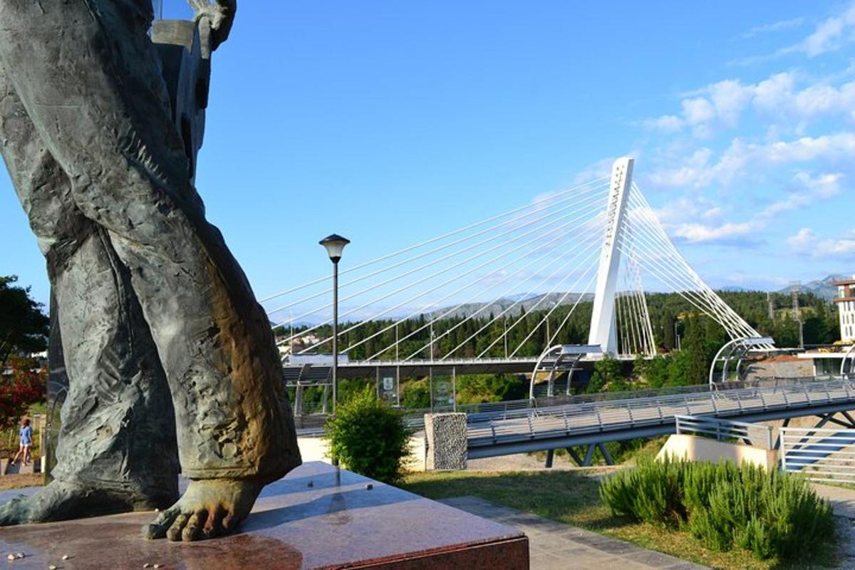 una statua di una persona in piedi accanto a un ponte