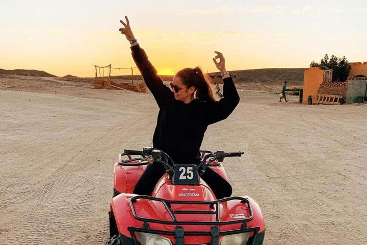 una donna seduta su una motocicletta nel deserto