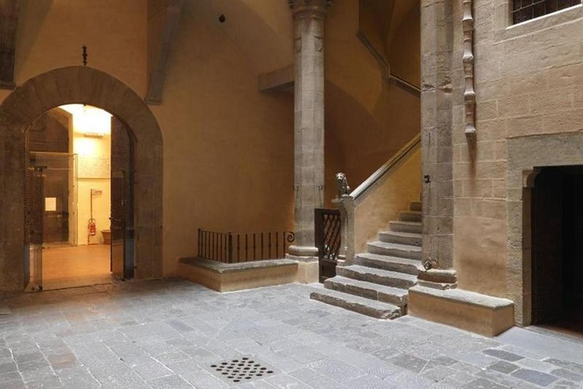 Un pasillo de un edificio con escaleras y un arco.