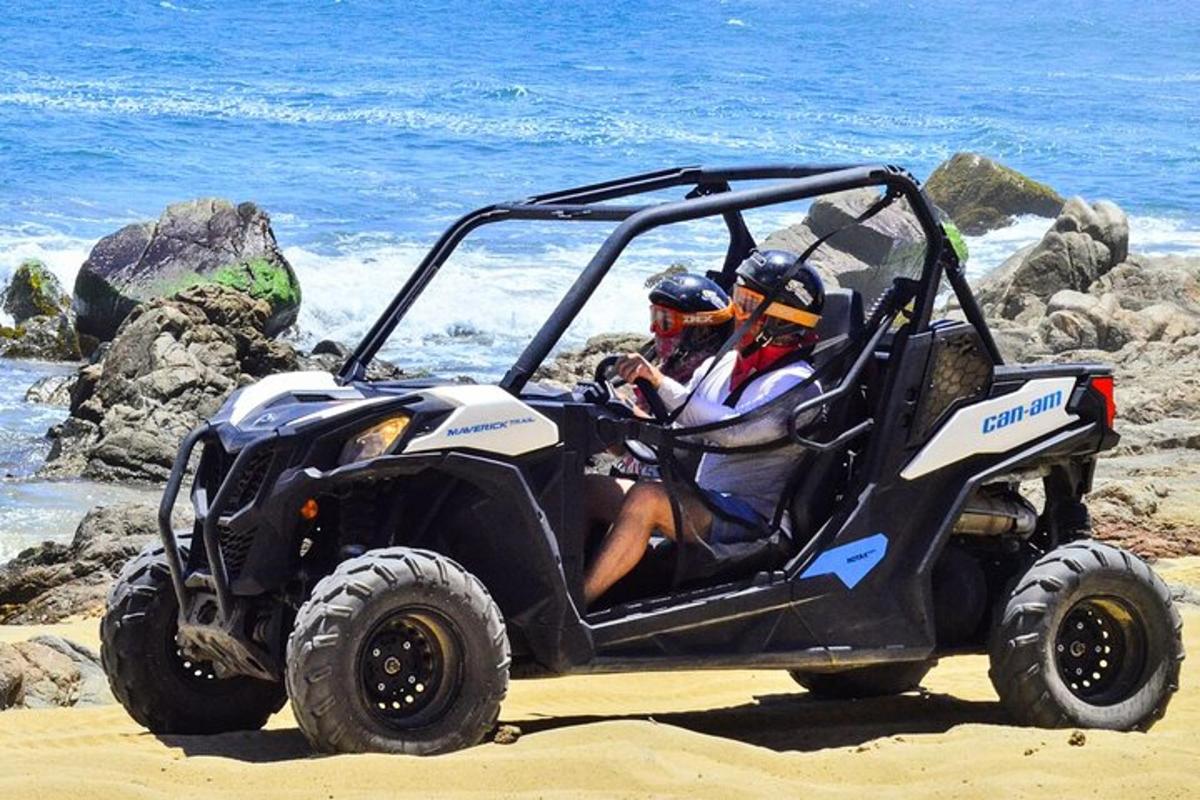 két ember ül egy ATV-ben a tengerparton