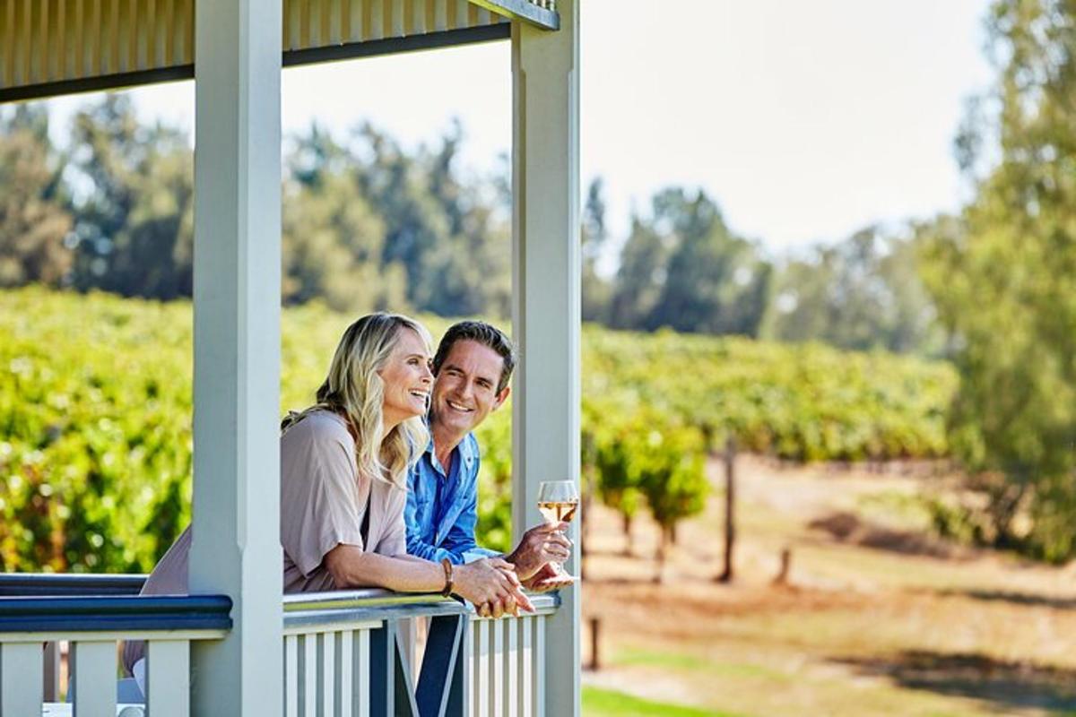 a man and woman standing on a porch with a glass of wine