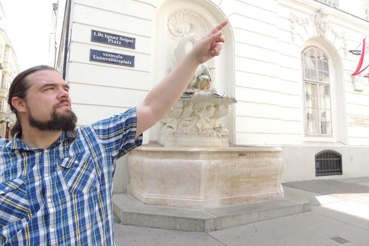 muž ukazující na sochu před budovou