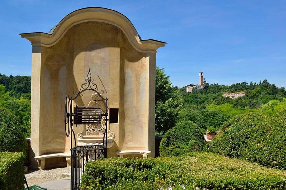 a stone arch with a statue in a garden