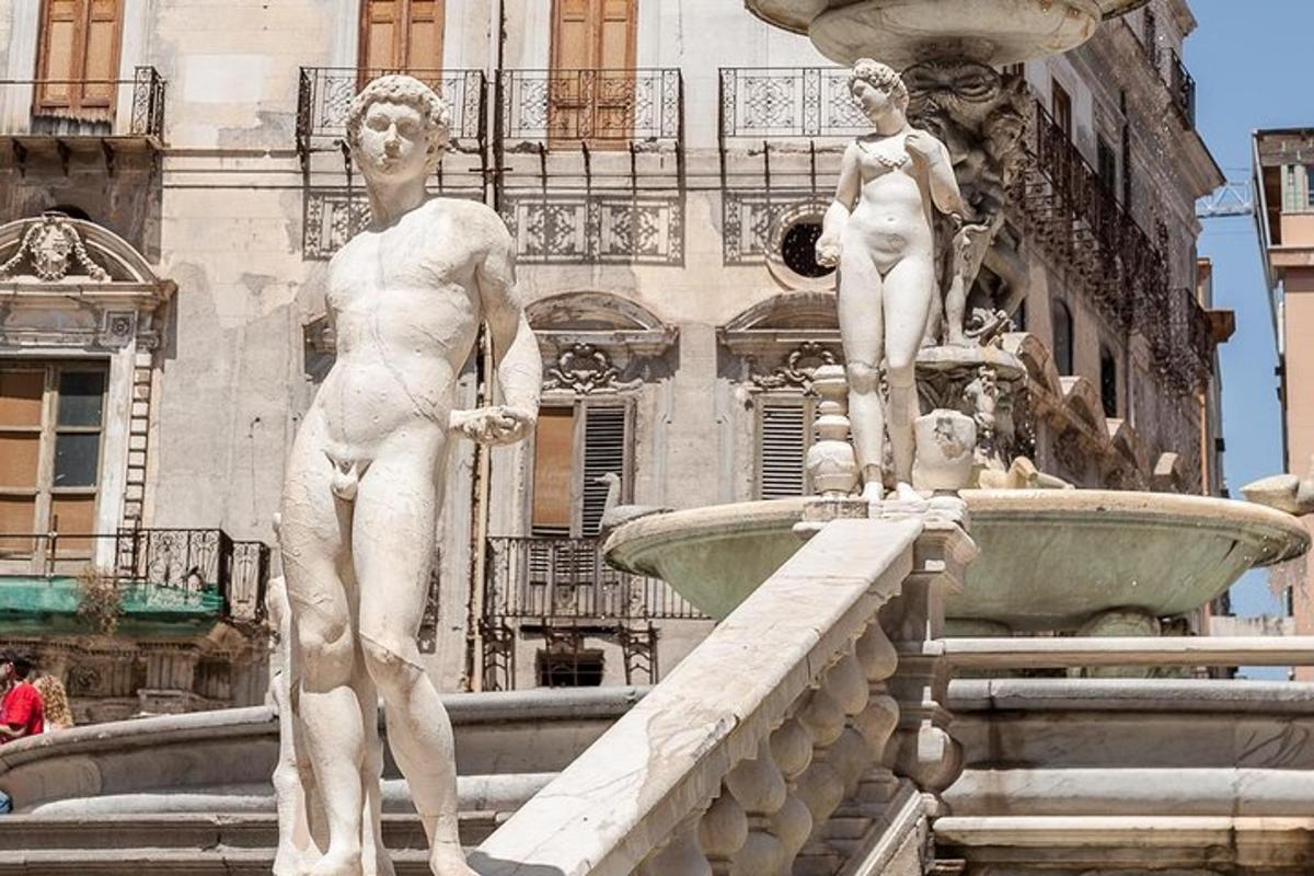 a fountain with two statues in front of a building