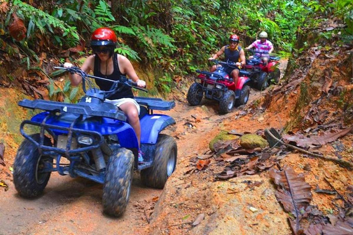 tre persone in sella a quad su una pista sterrata